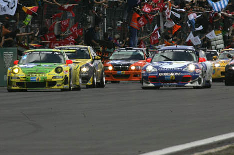 Den vindende Porsche (tv) på vej over målstregen efter 24 hårde timer på Nürburgring.